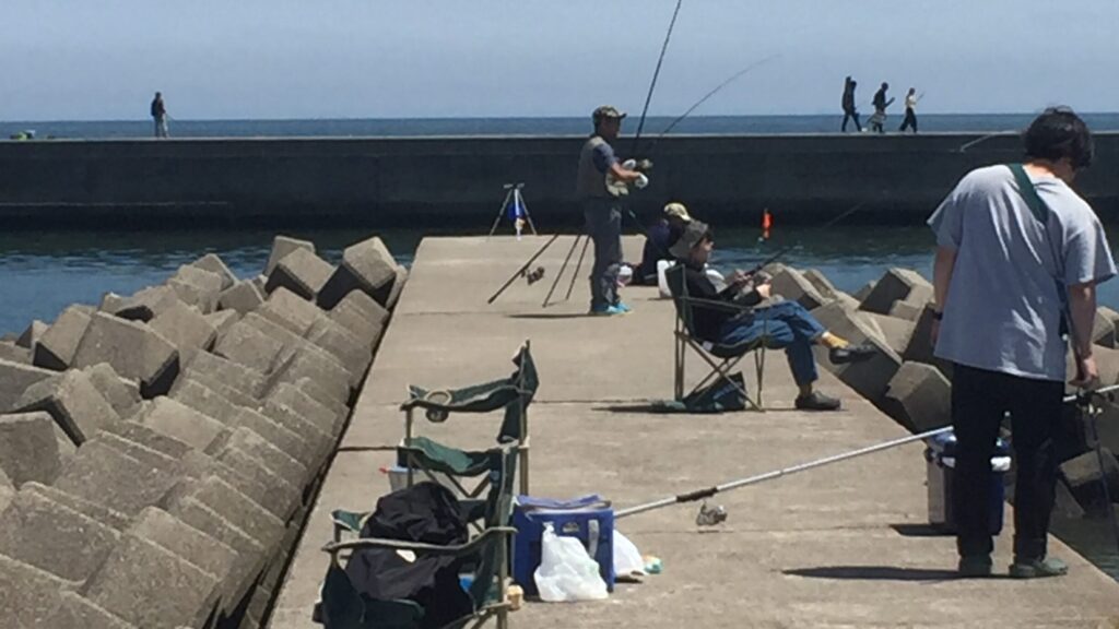 堤防で海釣りを楽しむ人達